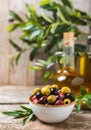 Green, black and red olives, olive oil on a brown wooden background. Royalty Free Stock Photo