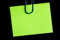 green blank note pinned to a black notice board with a paper clip Royalty Free Stock Photo