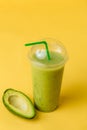 Green blended drink with avocado isolated yellow background