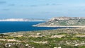 The green and blue coastal line with rocks, bays and mountains