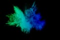 Green blue color powder explosion cloud isolated on black background. Royalty Free Stock Photo