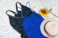 Green and blue dresses, hat and sunflower on white fur. Fashionable concept, top view Royalty Free Stock Photo