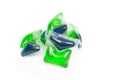 Green and blue gel capsules with laundry detergent Royalty Free Stock Photo