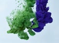 Green and blue ink drop in water over gray background Royalty Free Stock Photo