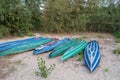 Green and blue kayaks, canoe boats drying on sand