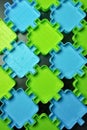 Green and blue puzzle like toys on a brown wooden background. Royalty Free Stock Photo