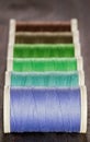 Green and blue spools of thread on dark background Royalty Free Stock Photo