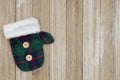Green and blue tartan Christmas mitten background with weathered wood
