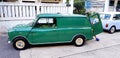 Green and Blue/white classic Mini cooper van parked on the street and in front of house Royalty Free Stock Photo