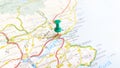 A green board pin stuck in Dundee on a map of Scotland
