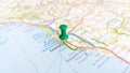 A green board pin stuck in Livorno on a map of Italy