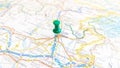 A green board pin stuck in Udine on a map of Italy