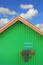 Green boat hous with traditional bavarian window, against blue s