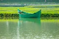 A green boat without passengers was parked on the edge of the lake Royalty Free Stock Photo