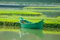 A green boat without passengers was parked on the edge of the lake Royalty Free Stock Photo