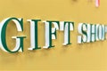 Green bold Giftshop signage on a yellow wall