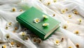 Green book surrounded by daisies on a white fabric. Soft and serene setting. Suitable for nature-inspired or book-related projects Royalty Free Stock Photo