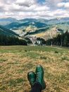 Green boots in front of mountain view