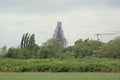 Green borders of Dender river, with tower of Saint Aldegondis church in Mespelare  under renovation Royalty Free Stock Photo