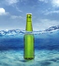 Green bottle of fresh beer with water droplets in sea ocean Royalty Free Stock Photo