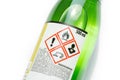 A green bottle of highly corrosive flammable chlorinated rubber nitro solvent with printed on warning symbols label, sticker