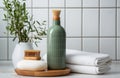 green bottle of shampoo, towel, wooden brushes, and herbs in a white ceramic bathroom Royalty Free Stock Photo