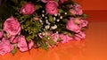 Green bouquet with small roses on an orange background. Pink small roses Royalty Free Stock Photo