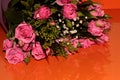 Green bouquet with small roses on an orange background. Pink small roses Royalty Free Stock Photo