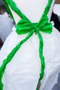 Green bow tied in white doll