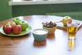 A green bowl of apples, bowl of porridge. Wooden Board with sliced apples. Glass of juice Royalty Free Stock Photo