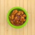 Green bowl with chicken chunks in barbecue sauce Royalty Free Stock Photo