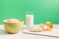 green bowl with dry oatmeal, staak of milk and sliced banana on wooden table Royalty Free Stock Photo