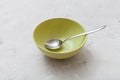 Green bowl with metal spoon on gray concrete Royalty Free Stock Photo