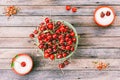 Green bowl with ripe cherry berries and cups with sugar on a wooden background Royalty Free Stock Photo