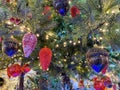 Green branches of a fluffy Christmas festive New Year tree with toys in balls and bright glowing light bulbs and garlands Royalty Free Stock Photo