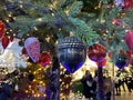 Green branches of a fluffy Christmas festive New Year tree with toys in balls and bright glowing light bulbs Royalty Free Stock Photo