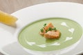 Green broccoli cream soup puree with filleted salmon and lemon