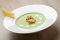 Green broccoli cream soup puree with filleted salmon and lemon