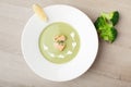 Green broccoli cream soup puree with filleted salmon and lemon