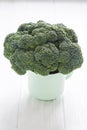 Green broccoli in tea cup on a white wooden table Royalty Free Stock Photo