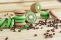 Green and brown french macarons with kiwi, coffee beans and mints decorations Royalty Free Stock Photo