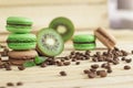 Green and brown french macarons with kiwi, coffee beans and mints decorations