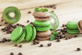 Green and brown french macarons with kiwi, coffee beans and mints decorations Royalty Free Stock Photo