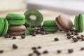 Green and brown french macarons with kiwi, coffee beans and mints decorations Royalty Free Stock Photo