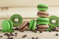 Green and brown french macarons with kiwi, coffee beans and mints decorations Royalty Free Stock Photo
