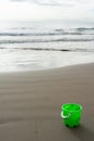 Green bucket on the beach sand Royalty Free Stock Photo