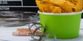 green bucket with nachos, against the background of a set for the movie