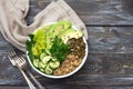 Green Buddha Bowl with lentils, quinoa, avocado, cucumber, fresh lettuce, herbs and seeds