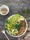 Green Buddha Bowl with lentils, quinoa, avocado, cucumber, fresh lettuce, herbs and seeds Royalty Free Stock Photo