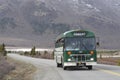 A green bus on a road in Denali National Park